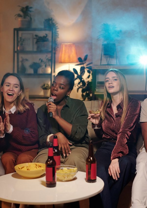 group-of-young-intercultural-friends-singing-karaoke-while-sitting-on-couch.jpg